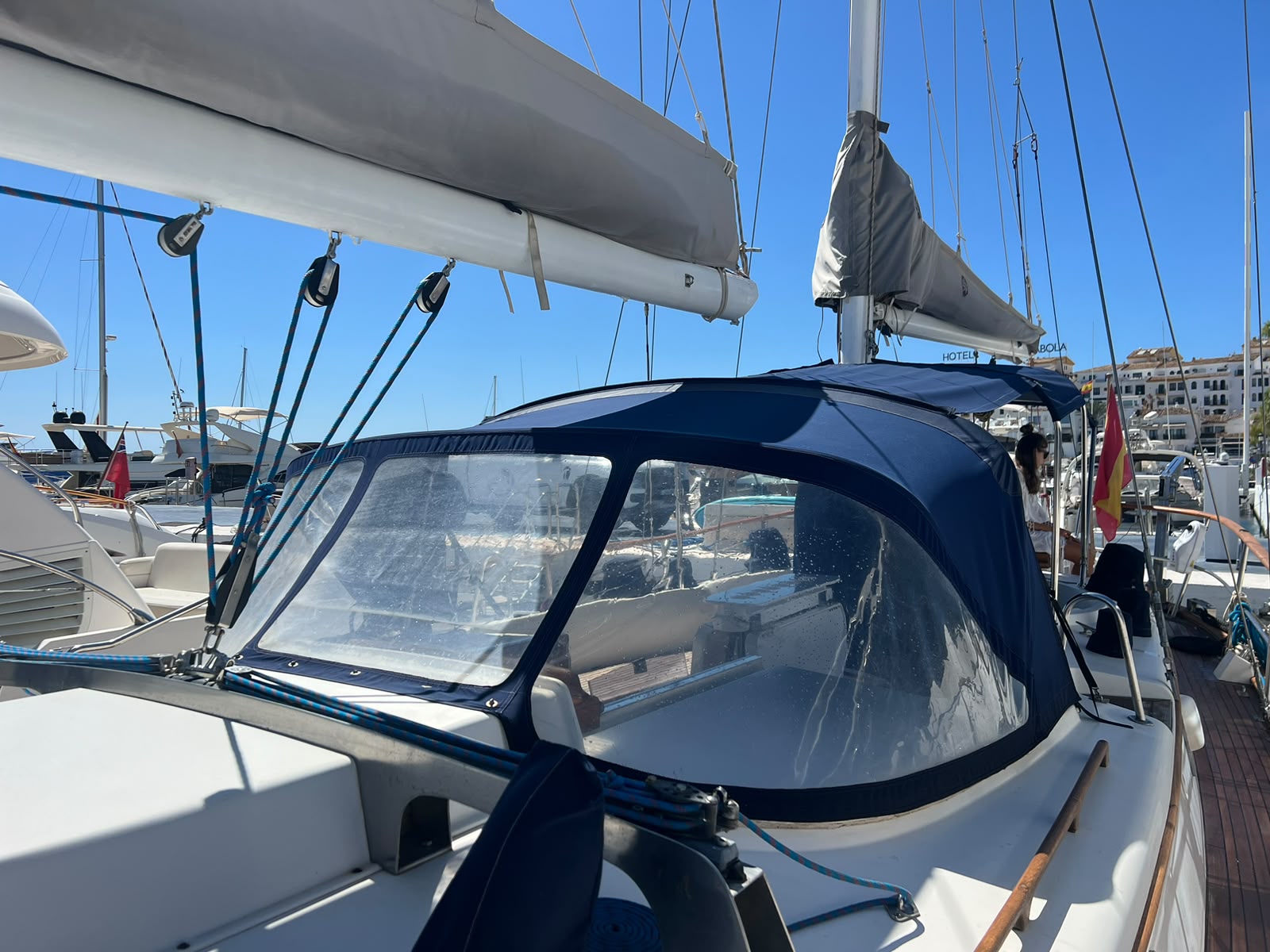 Capota azul del velero y mayor recogida en el puerto