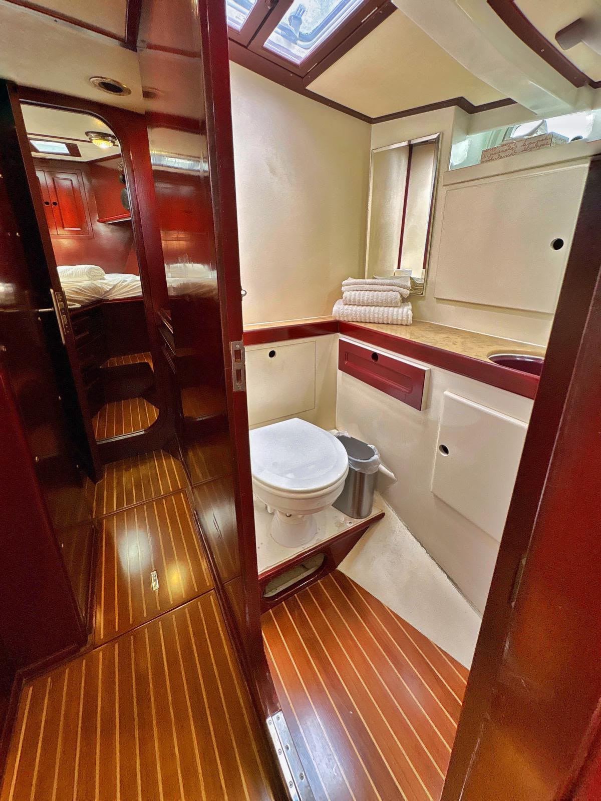Baño del velero con vistas al camarote desde el pasillo