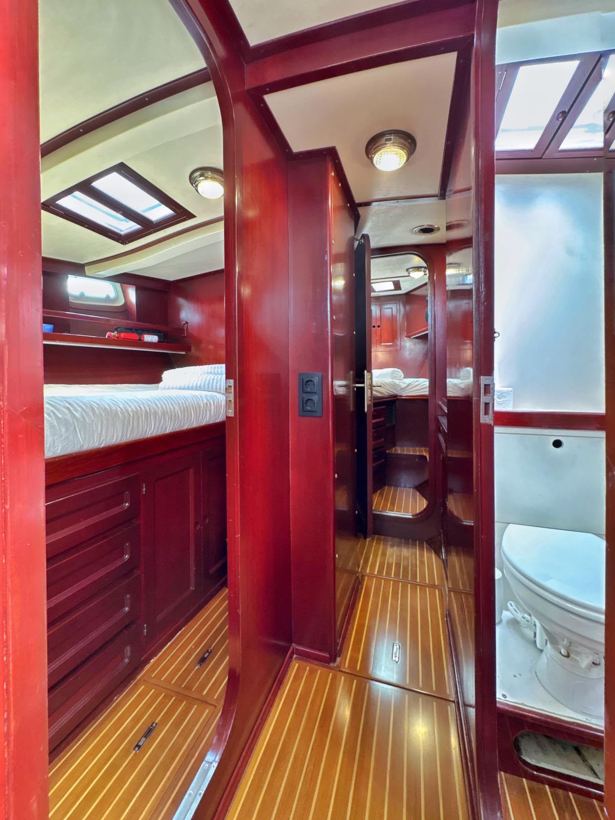 Pasillo interior de teca que conecta camarotes y baños